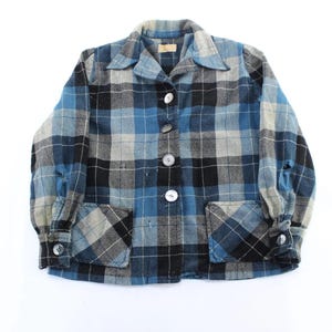 May include: A blue, black, and gray plaid jacket with a collared neckline, button-up front, and two front pockets. The jacket has long sleeves with buttoned cuffs and large white buttons.