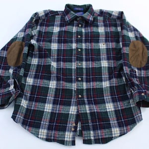 May include: A long-sleeved plaid shirt in shades of navy, green, and burgundy, featuring brown elbow patches. The shirt has a button-down front and a collared neckline. The plaid pattern is a classic design.