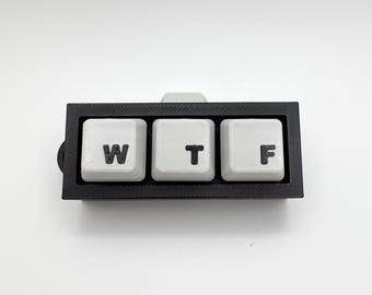 May include: A black plastic key chain with three white keys labelled "W", "T", and "F".