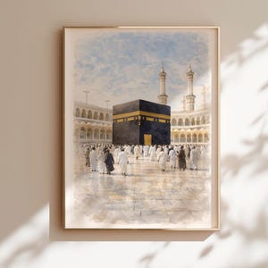 Pode incluir: Pintura em aquarela emoldurada da Kaaba em Meca. A obra retrata a Kaaba negra em forma de cubo com uma borda dourada, cercada por pessoas vestidas de branco. O fundo apresenta uma mesquita com minaretes e um céu azul.