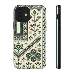 Puede incluir: Funda de teléfono con un fondo color crema y un patrón geométrico verde oscuro. El diseño presenta motivos florales y en forma de cruz, con un borde de pequeñas formas repetidas. El lateral de la funda es negro.