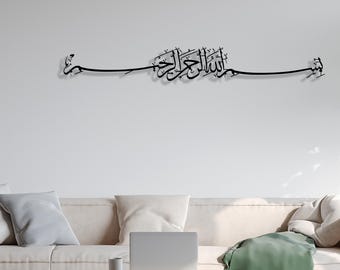 May include: Black metal wall art featuring Arabic calligraphy. The artwork is mounted on a white wall above a beige sofa. The calligraphy is a flowing script design, adding an elegant touch to the room's decor.