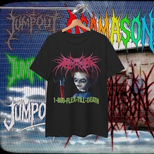 May include: Black t-shirt featuring a graphic of a doll holding an axe, with the text "1-800-FLEX-TILL-DEATH" in green. The doll has red hair and a sinister expression. The shirt is hanging on a wooden hanger.