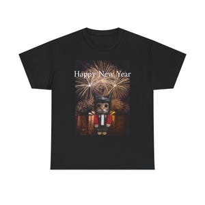 May include: Black t-shirt featuring a graphic of a cat wearing a hat and jacket, set against a fireworks display. The text "Happy New Year" is displayed above the graphic. A festive design for the new year.