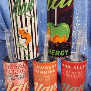 May include: A collection of insulated tumblers with straws, featuring various designs and flavors. The tumblers include "Witch's Brew," "Cotton Candy," "Rawberry Sunrise," and "Pink Slush" with colorful graphics and text.