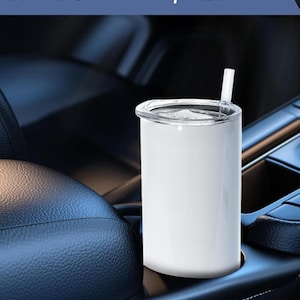 May include: A white tumbler with a clear lid and straw sits in a car cup holder. The text "Fits most car cup holder" is above the tumbler. The tumbler is cylindrical and appears to be made of metal.