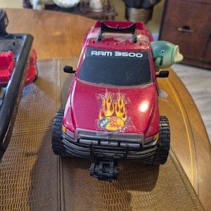 Camioneta pickup Ram 3500 de Bass Pro Shop y bote y remolque negros de Bass Pro Shop. imagen 1