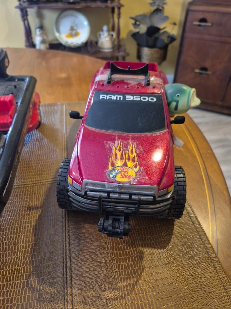 Camioneta pickup Ram 3500 de Bass Pro Shop y bote y remolque negros de Bass Pro Shop. imagen 1