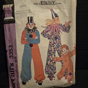May include: Vintage McCall's sewing pattern for a clown costume. The pattern includes instructions for making a clown costume for an adult and two children. The pattern is labeled "Make it EASY, please" and includes a step-by-step guide. The pattern is for sizes 2-4.