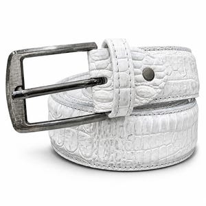 May include: A white belt featuring a textured crocodile-embossed pattern throughout the strap. The belt includes a rectangular, dark metallic buckle with a brushed finish and a single matching loop to secure the end of the strap in place.