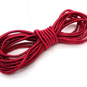 May include: A spool of red elastic cord, perfect for crafting and sewing projects.