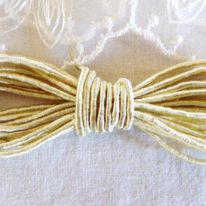 Può includere: Un rotolo di cordoncino elastico color avorio, perfetto per progetti di artigianato e cucito.