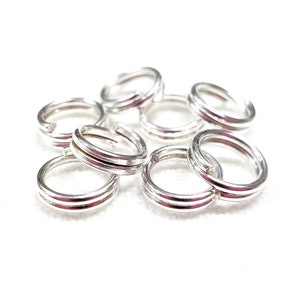 Peut inclure: Gros plan sur un tas de anneaux de saut argentés. Les anneaux sont tous de la même taille et ont une finition lisse et polie.