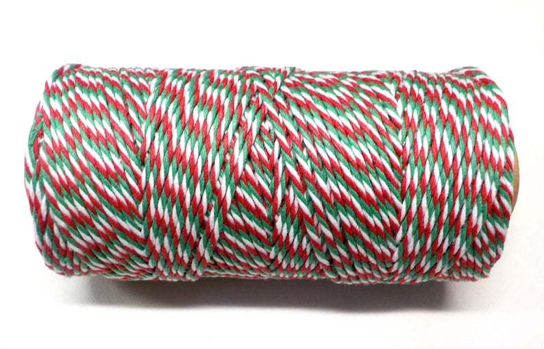 May include: A roll of red, white, and green baker's twine. The twine is twisted together in a striped pattern.