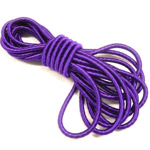 Puede incluir: Un rollo de cordón elástico morado, perfecto para proyectos de manualidades y costura.