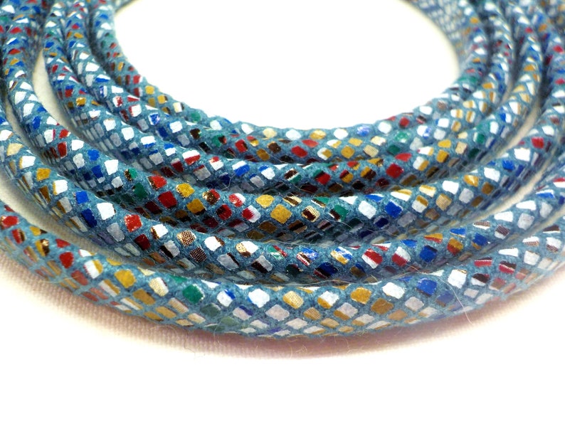May include: A close-up of a blue cord with a colorful, patterned design. The cord is made of a soft, textured material and has a subtle sheen.