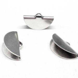 Op de afbeelding: Drie zilveren metalen halve cirkel eindkappen voor het maken van sieraden.