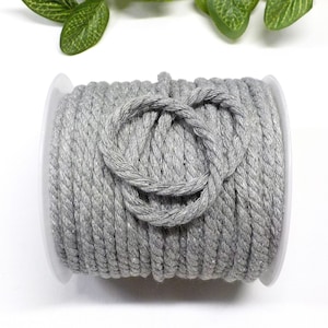 Puede incluir: Un carrete de cordón de algodón gris plateado, perfecto para manualidades y proyectos de bricolaje.