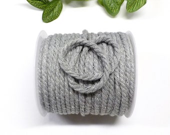 May include: A spool of silver grey cotton cord, ideal for crafting and DIY projects.