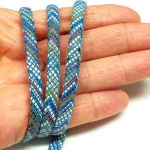 May include: Three strands of teal blue leather cord with a white, gold, red, and blue geometric pattern.