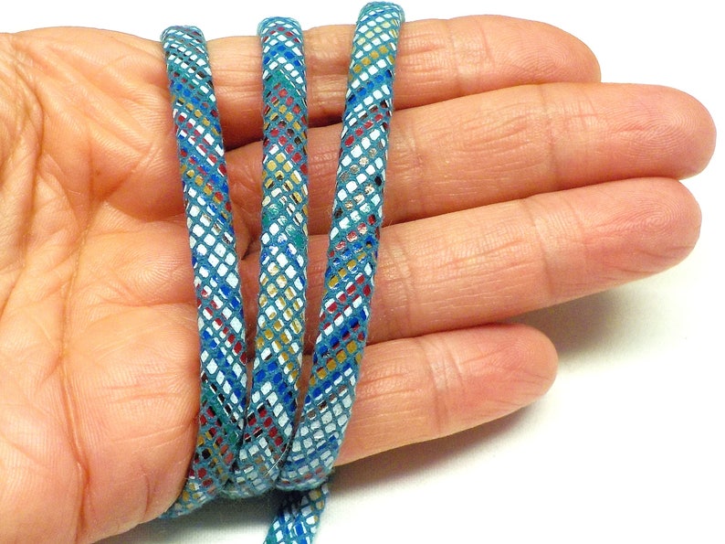 May include: Three strands of teal blue leather cord with a white, gold, red, and blue geometric pattern.