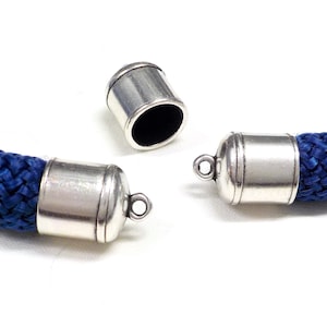 May include: Two silver metal cord end caps with a loop on one end. The cord end caps are on a blue braided cord.