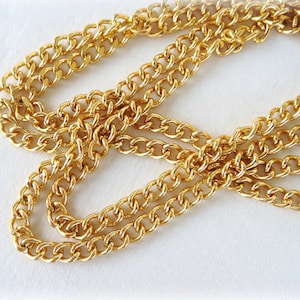 Può includere: Una collana a catena d'oro con uno stile a maglie a curb. La catena è spessa e ha una finitura lucida.