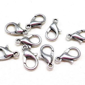 May include: A group of ten silver-toned lobster clasps, a type of fastener used in jewelry making.