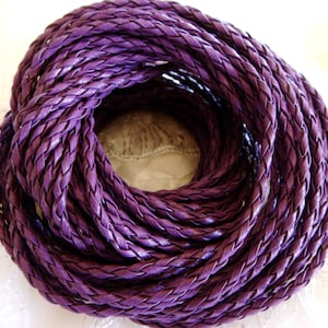 Könnte beinhalten: Nahaufnahme eines Knäuels aus geflochtenem, violettem Lederband. Das Band ist etwa 5 mm breit und eignet sich perfekt zum Basteln von Schmuck, Taschen und anderen Accessoires.