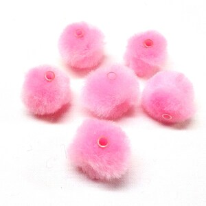 May include: Six pink fluffy pom poms with a small hole in the centre of each.