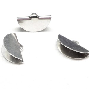 Op de afbeelding: Drie zilveren metalen halfronde kralencaps. De caps zijn aan &eacute;&eacute;n kant open en hebben een kleine lus aan de bovenkant.