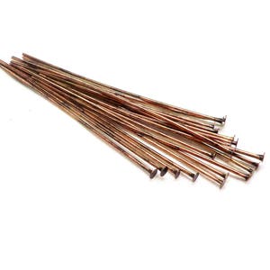 Puede incluir: Un paquete de 20 alfileres de cabeza de cobre, cada uno con una cabeza plana. Los alfileres miden aproximadamente 2,5 cm de largo.