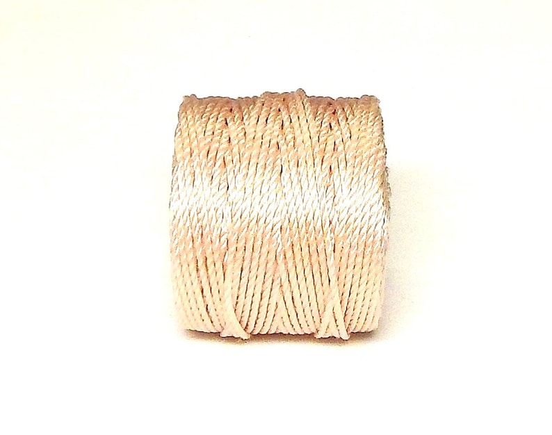 May include: A spool of cream-colored embroidery floss.