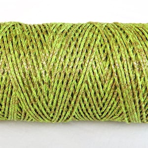 May include: A spool of lime green and gold metallic twine. The twine is made of a thin, braided cord with a subtle shimmer.