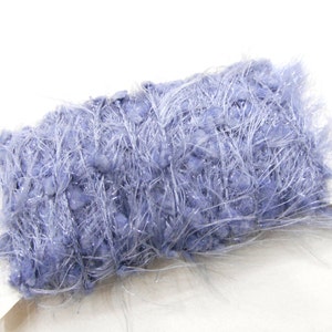 May include: A roll of light blue yarn with a fuzzy, textured appearance. The yarn has a mix of short, nubby sections and long, wispy fibers, creating a soft and textured look. The yarn is ideal for knitting and crochet projects.