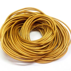 May include: A spool of gold leather cord. The cord is approximately 3mm thick and is wound into a tight coil.