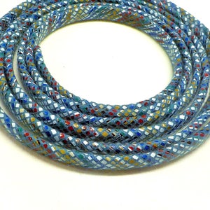 May include: A close-up of a blue cord with a multi-colored diamond pattern. The cord is coiled into a circle.