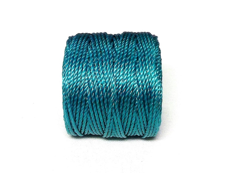 May include: A spool of teal blue embroidery floss.