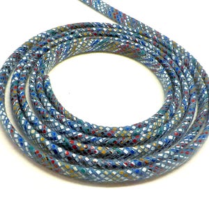 May include: A close-up of a blue cord with a multi-colored geometric pattern. The cord is coiled into a circle.