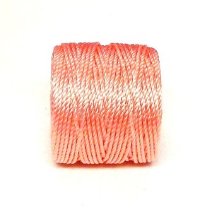 May include: A spool of pink embroidery floss.