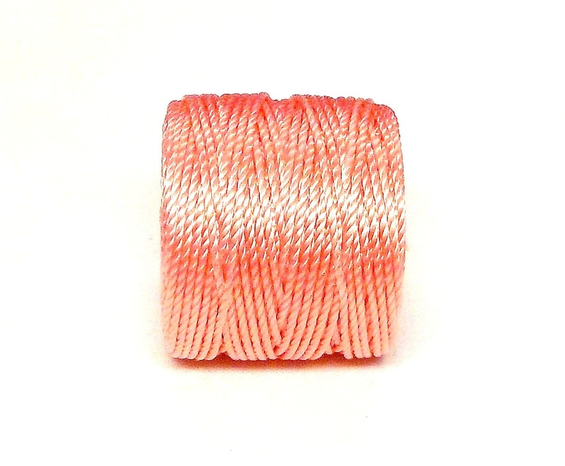 May include: A spool of pink embroidery floss.