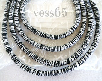 May include: A close-up of a black and white striped cord, with multiple strands of the cord layered on top of each other. The cord is made of a woven material and has a rough texture.