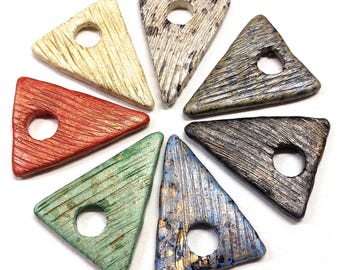 May include: Seven triangular ceramic pendants with a hole in the center. The pendants are in various colors and textures, including red, green, blue, gray, and white.