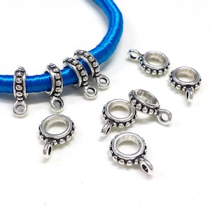 Può includere: Cappucci per perline in metallo color argento con un design di perline decorative. I cappucci hanno un piccolo anello sul fondo per fissarli a un cordoncino o una corda.