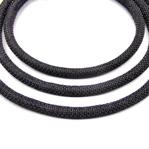 Puede incluir: Tres cordones trenzados negros con un acabado brillante.
