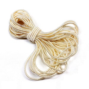 May include: A spool of ivory-coloured elastic cord, ideal for crafting and jewellery making.
