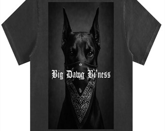 Puede incluir: Camiseta gris oscuro con un retrato en blanco y negro de un Doberman Pinscher con un pañuelo. El pañuelo tiene un diseño de cachemira. El texto "Big Dawg Bi'ness" está impreso en blanco en el pañuelo.