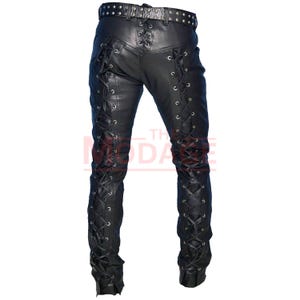 May include: Black leather pants with lace-up detailing on the sides. The pants have a belt loop and a buckle closure.