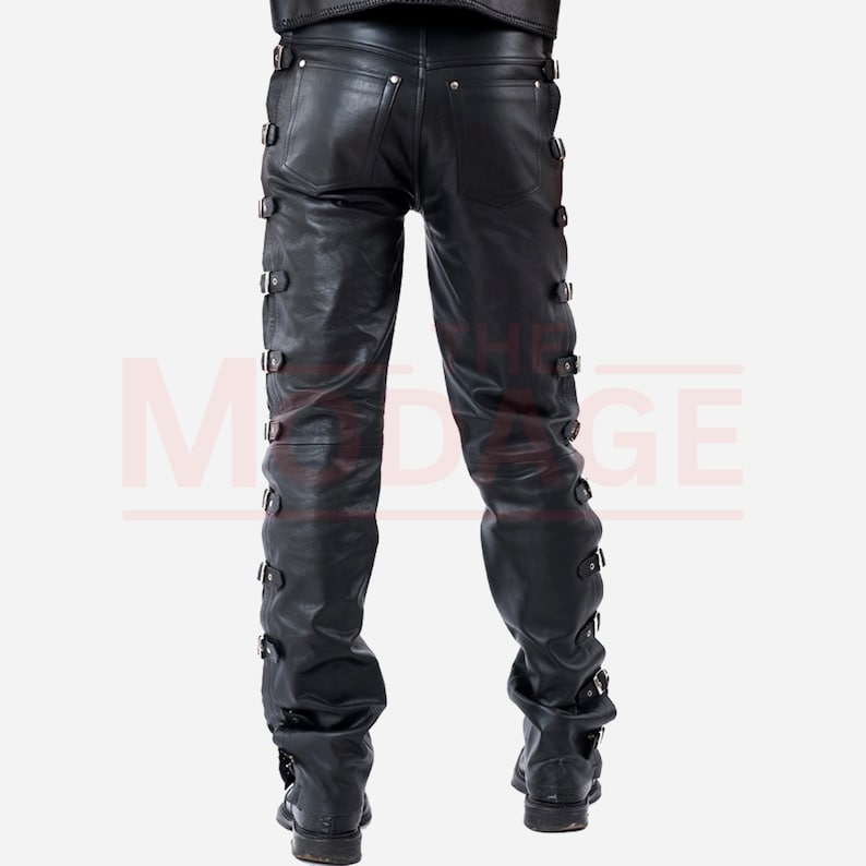 May include: Black leather trousers with multiple buckles down the sides of the legs.