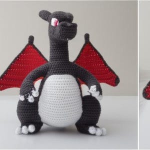 May include: Crocheted dragon toy in shades of gray, white, and red. The dragon has a long neck, large red wings, and a white belly. The toy is handmade and appears to be a character from a popular franchise.